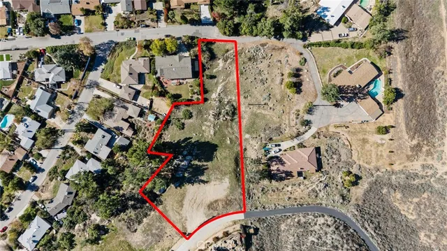 an aerial view of a house with a yard and large trees