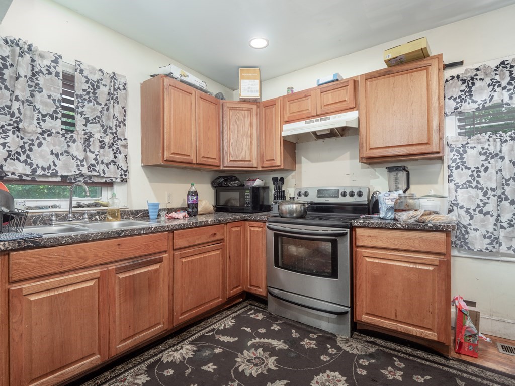 83 Canterbury Street Worcester, MA 01603 - Photo 34 of 42 a kitchen with stainless steel appliances granite countertop a stove a sink and a microwave