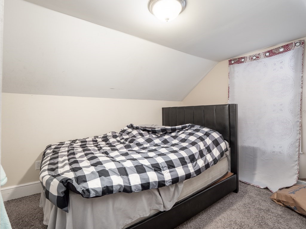 83 Canterbury Street Worcester, MA 01603 - Photo 41 of 42 a bedroom with a bed and wooden floor