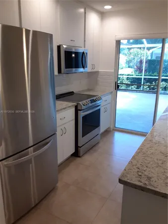 a kitchen with stainless steel appliances granite countertop a refrigerator and a sink