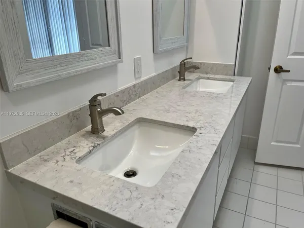 a bathroom with a granite countertop shower a toilet and a sink