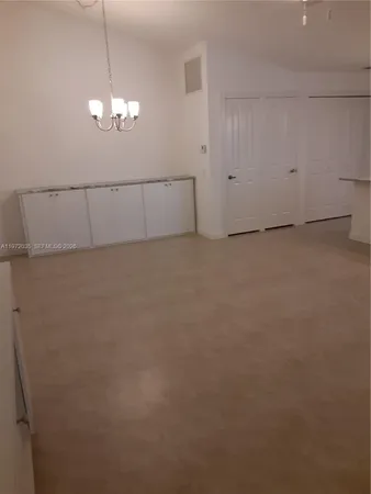 a view of a chandelier fan and refrigerator in a room