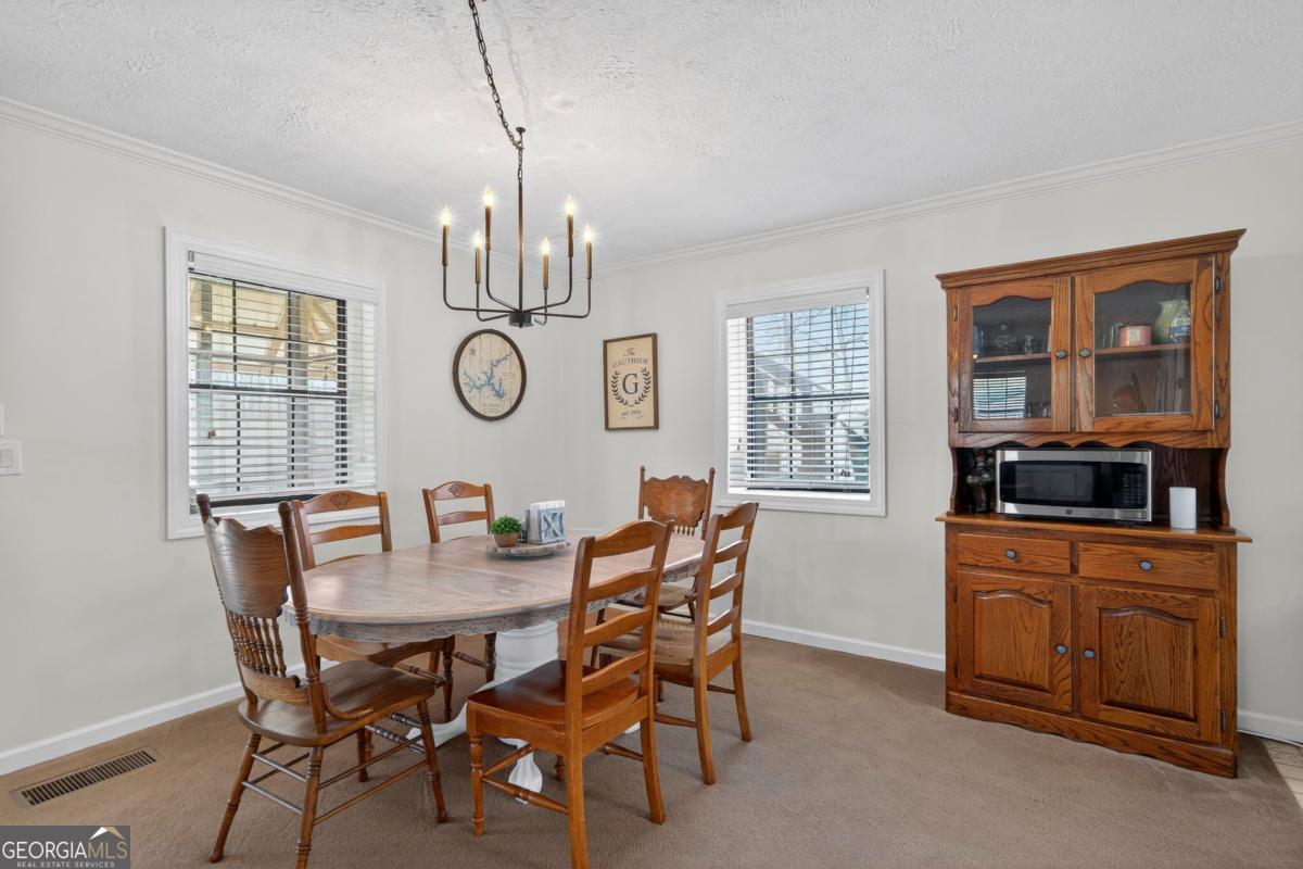 219 Hickory Pass Sparta, GA 31087 - Photo 12 of 62 a dining room with furniture a chandelier and wooden floor