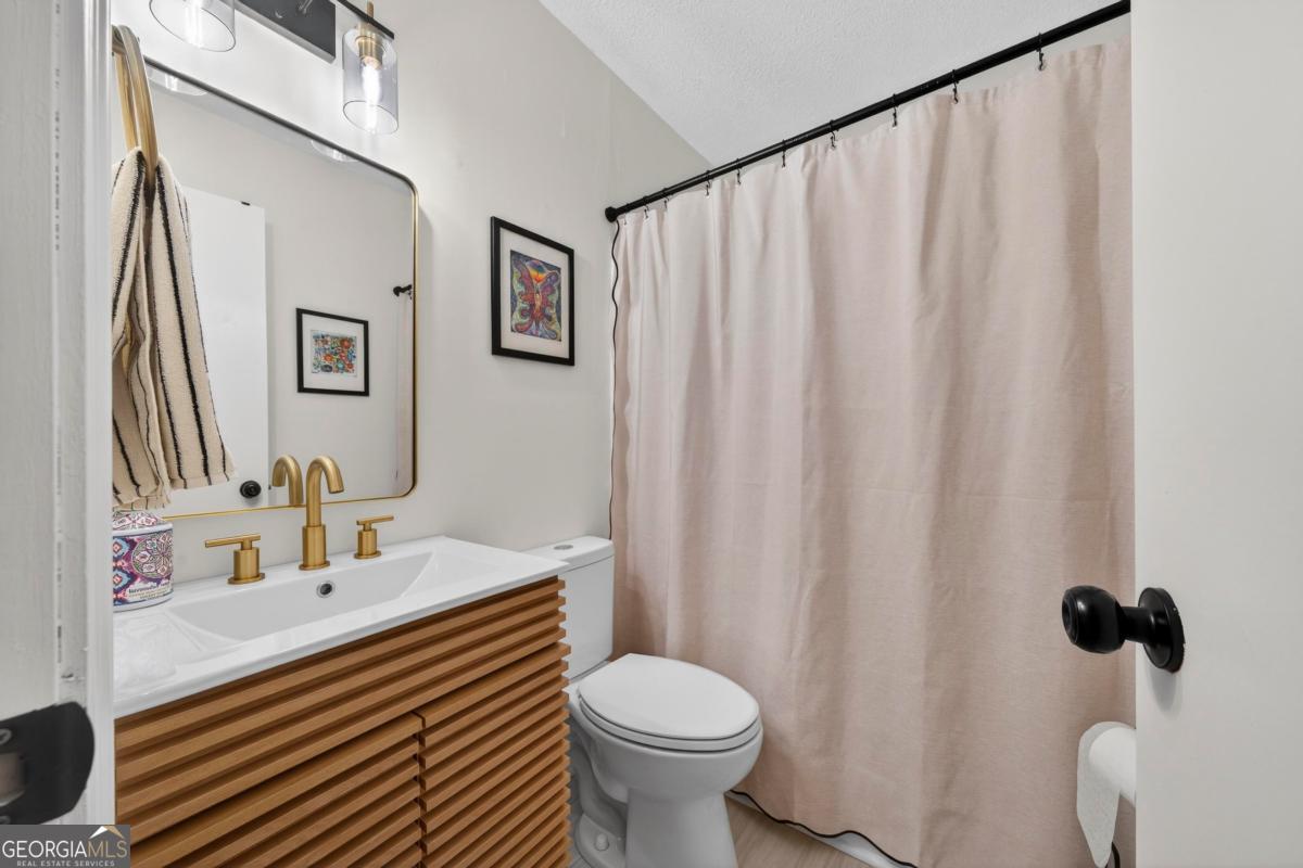 219 Hickory Pass Sparta, GA 31087 - Photo 19 of 62 a bathroom with a sink a toilet and a mirror