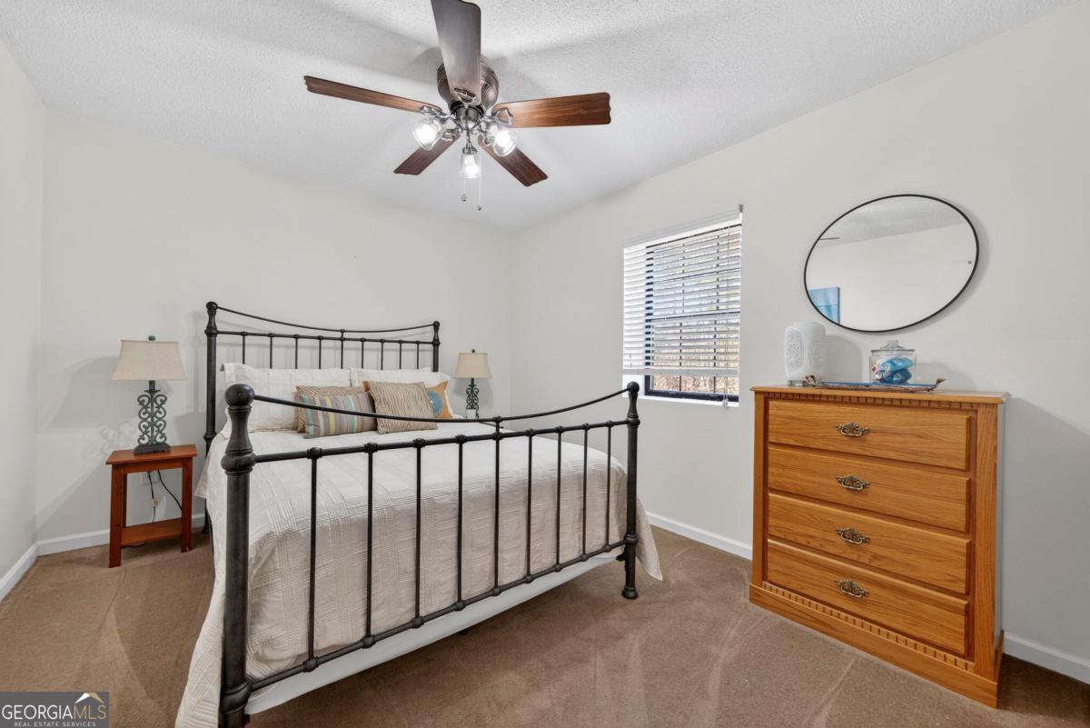 219 Hickory Pass Sparta, GA 31087 - Photo 34 of 62 a bedroom with a bed and a chandelier