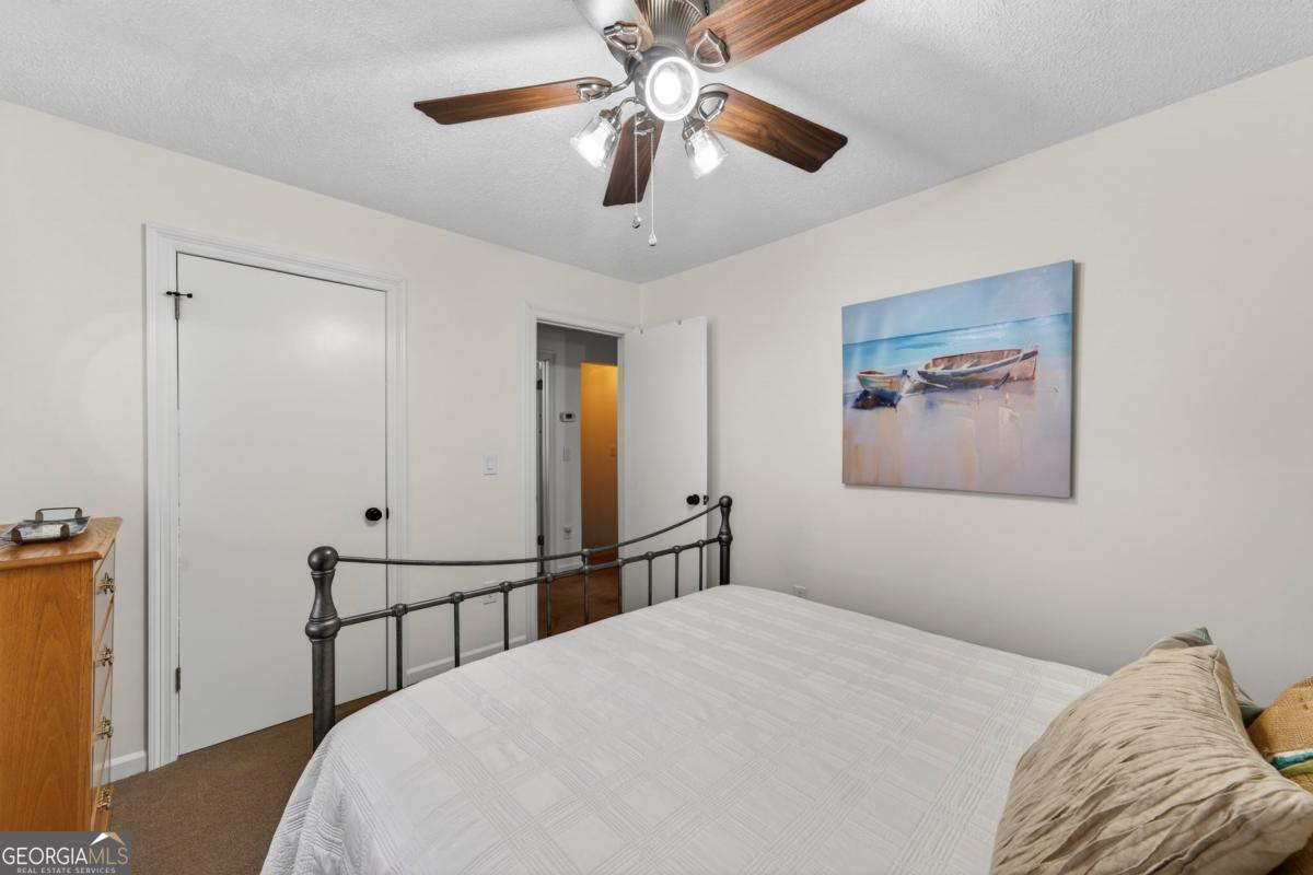 219 Hickory Pass Sparta, GA 31087 - Photo 35 of 62 a bedroom with a bed and a chandelier