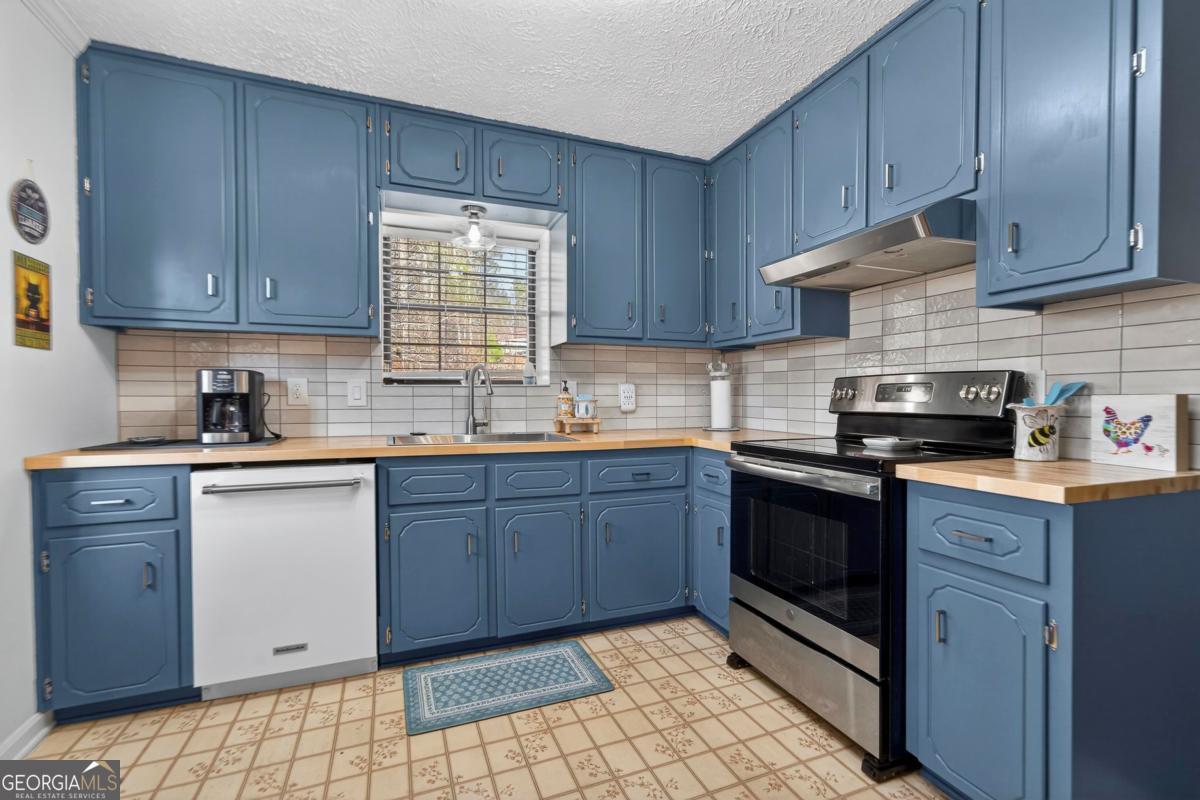 219 Hickory Pass Sparta, GA 31087 - Photo 7 of 62 a kitchen with granite countertop wooden cabinets stainless steel appliances and a sink