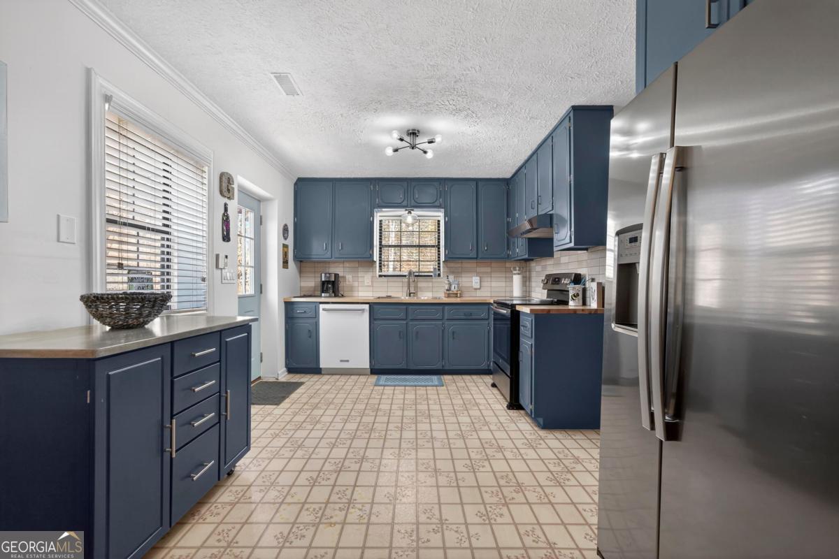 219 Hickory Pass Sparta, GA 31087 - Photo 8 of 62 a kitchen with stainless steel appliances granite countertop a refrigerator a sink dishwasher a stove with wooden cabinets