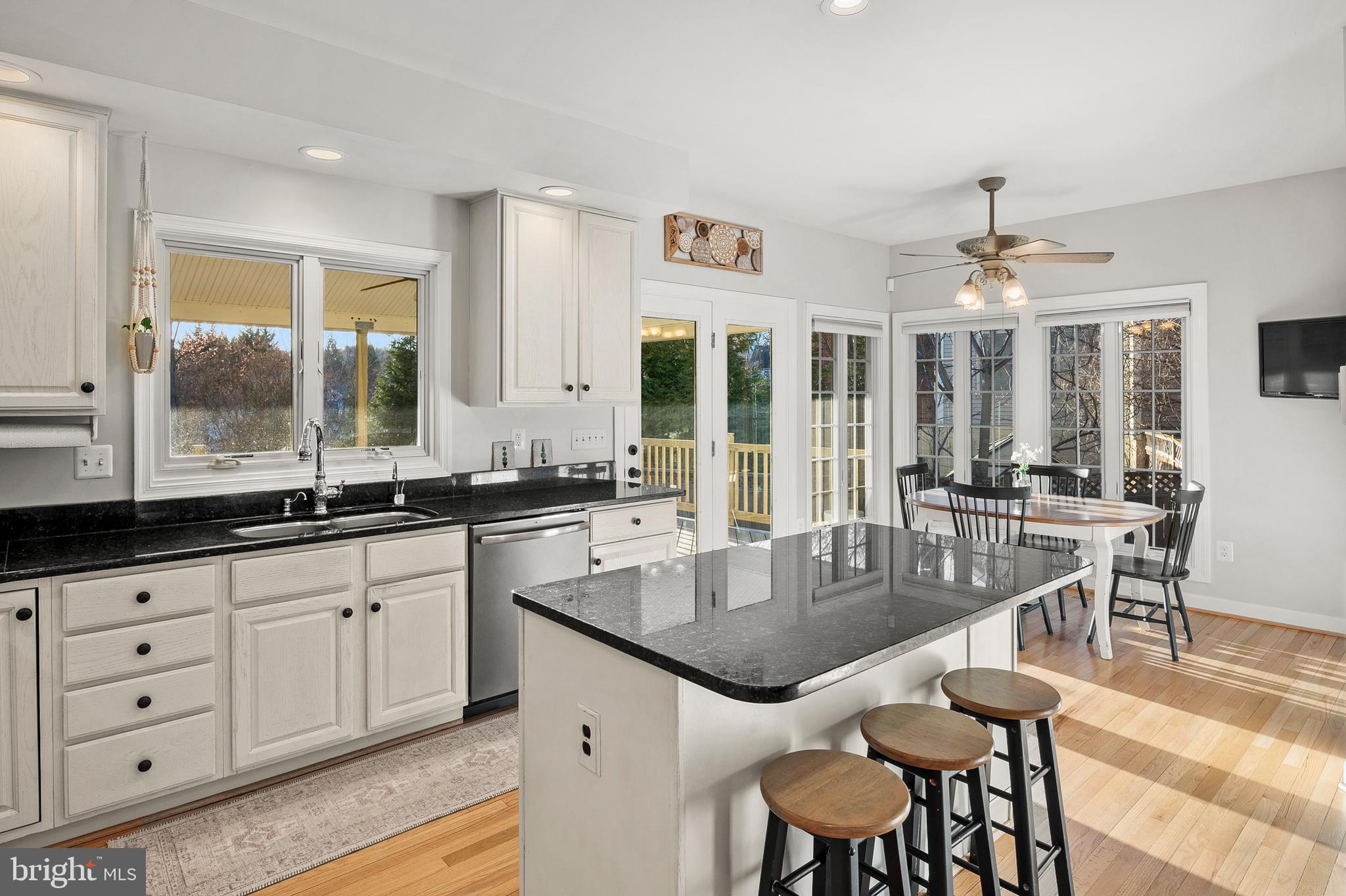 9916 Founders Way Damascus, MD 20872 - Photo 16 of 53 a kitchen with granite countertop a stove a sink a dining table and chairs
