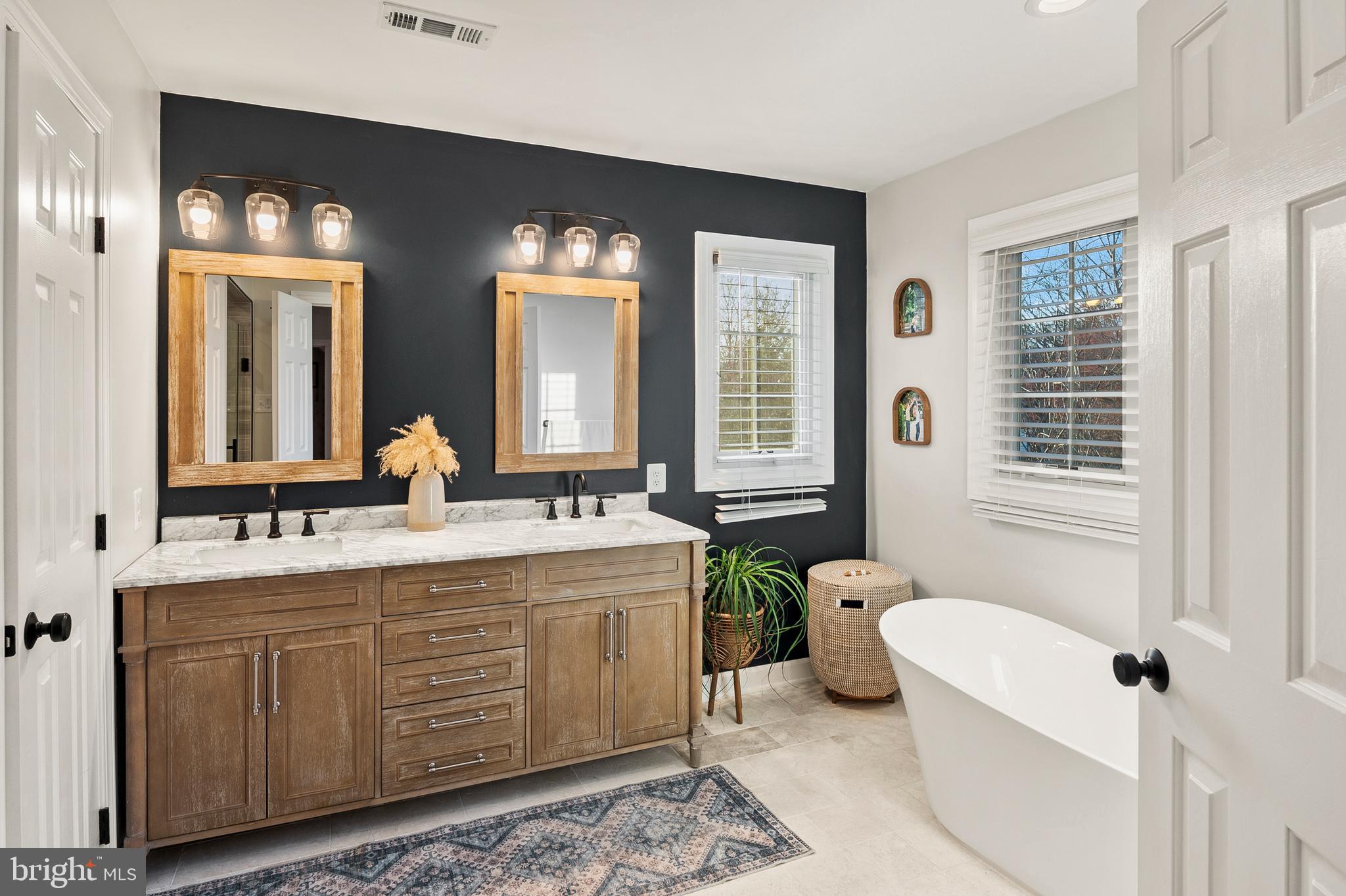 9916 Founders Way Damascus, MD 20872 - Photo 31 of 53 a bathroom with a double vanity sink toilet mirror and bathtub