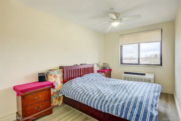 a bedroom with a bed and a dresser next to a window