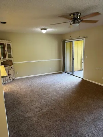 en empty room with windows and ceiling fan