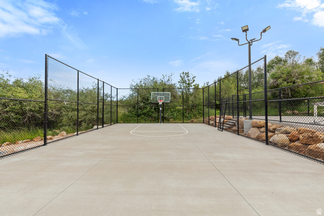 1489 Old Mill Road Montpelier, ID 83254 - Photo 18 of 21 Private concrete sport court featuring an adjustable basketball hoop, perimeter fencing, and integrated lighting