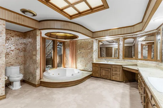 a bathroom with a tub a sink and a large mirror