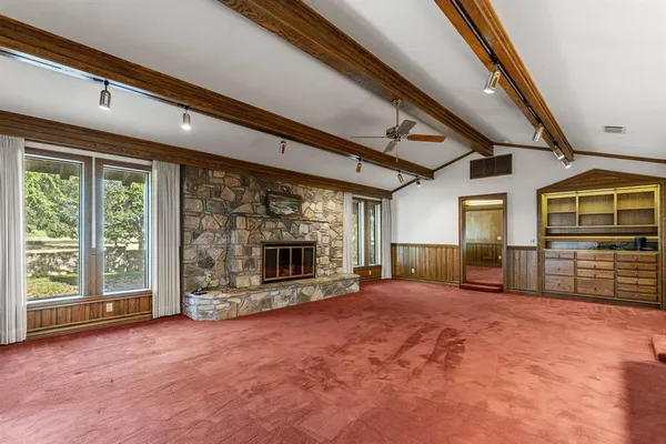 a view of an empty room with a fireplace and a window