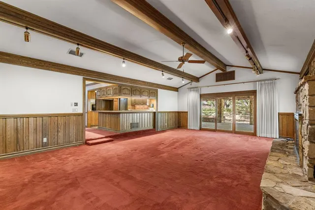 a view of an empty room with a fireplace and a window