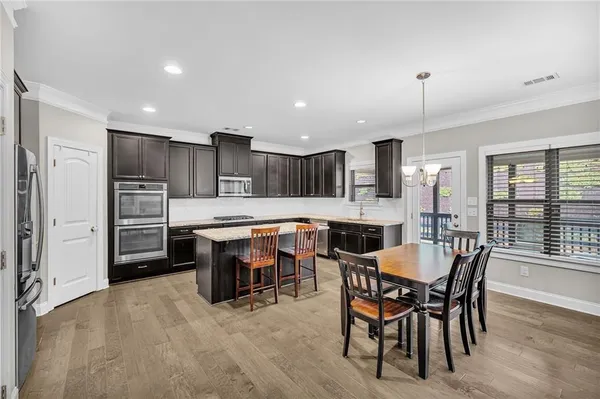 a large kitchen with a table and chairs