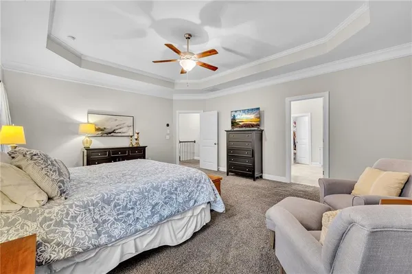 a bedroom with a bed a chandelier and mirror