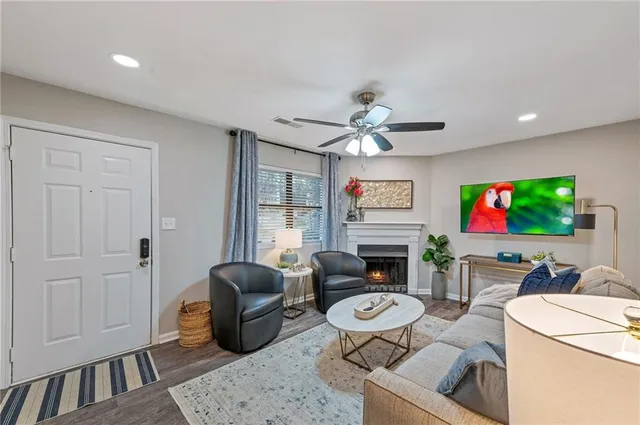 a living room with furniture a fireplace and a flat screen tv