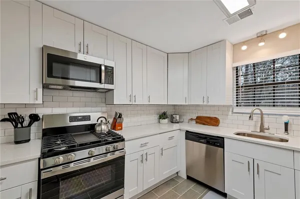 a kitchen with cabinets stainless steel appliances and sink