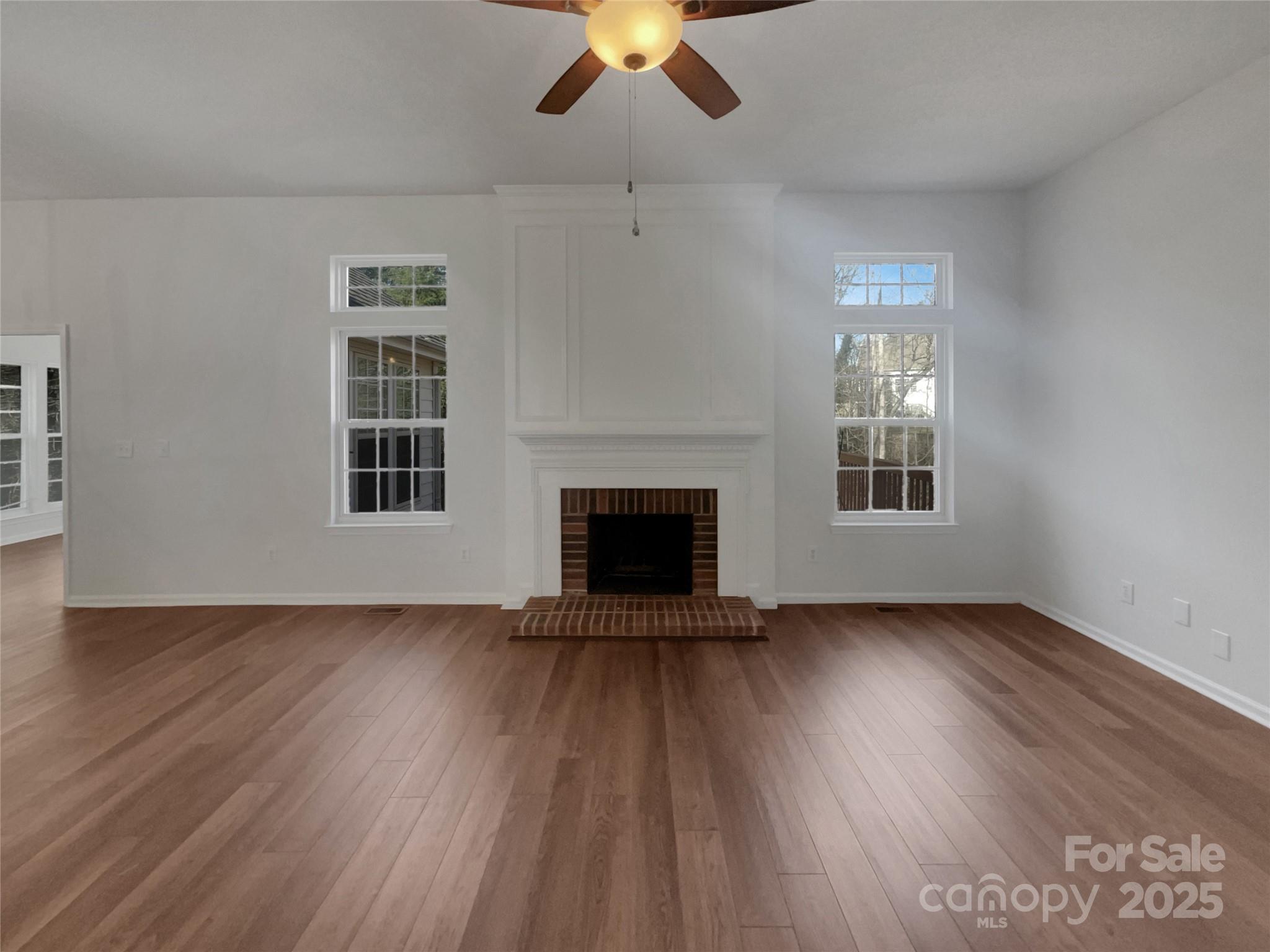 405 St George Road Fort Mill, SC 29708 - Photo 3 of 15 an empty room with wooden floor a chandelier fan and windows