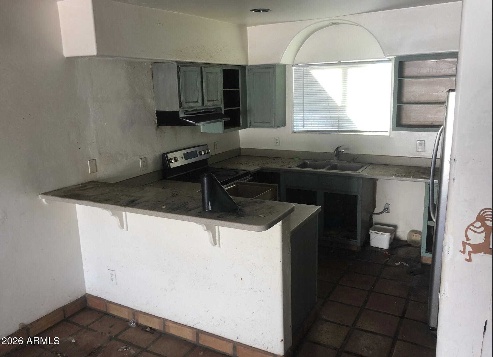 4260 West Mars Street Tucson, AZ 85741 - Photo 12 of 15 a kitchen with a sink a stove and a window