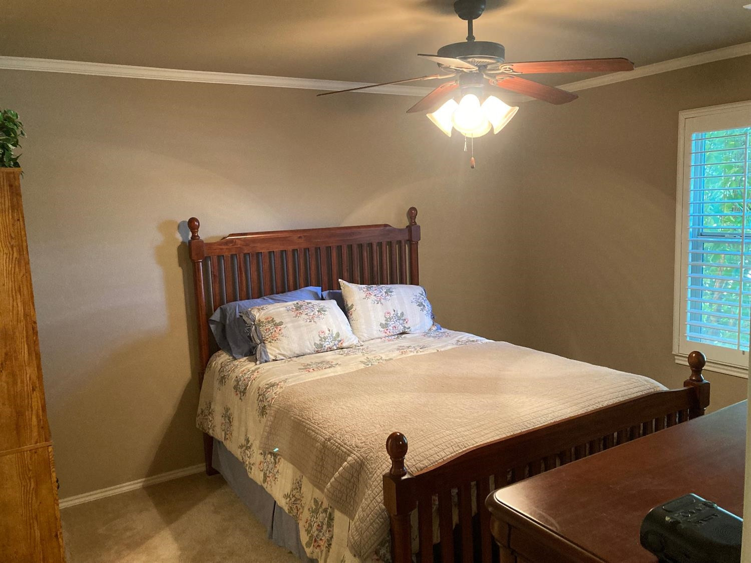 6120 75th Place Lubbock, TX 79424 - Photo 18 of 30 a bed sitting in a bedroom next to a window