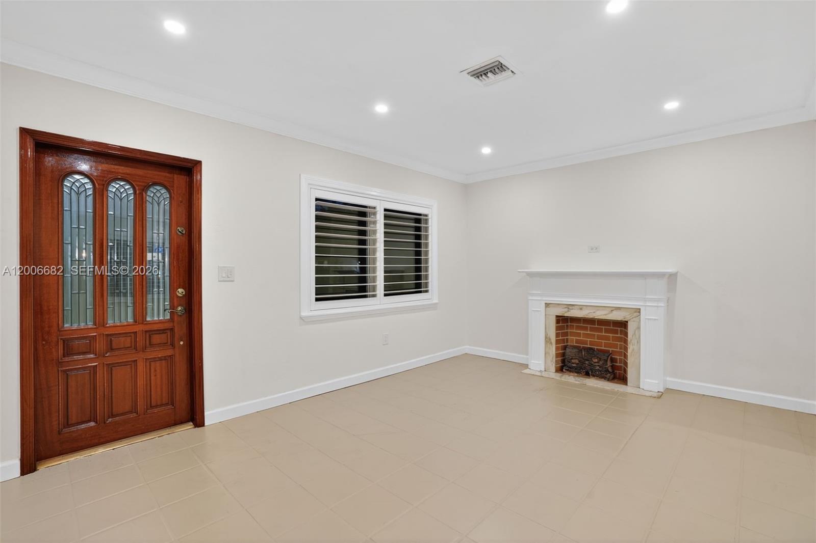1435 Blue Road Coral Gables, FL 33146 - Photo 5 of 31 an empty room with windows & cabinet a fireplace