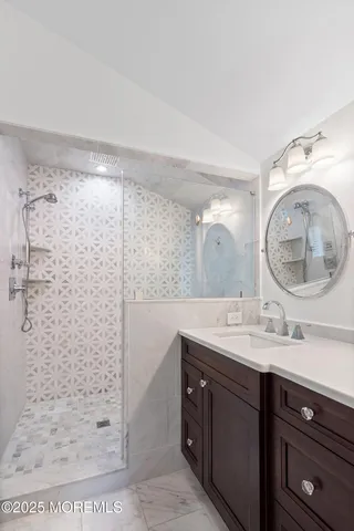 a bathroom with a double vanity sink mirror and shower