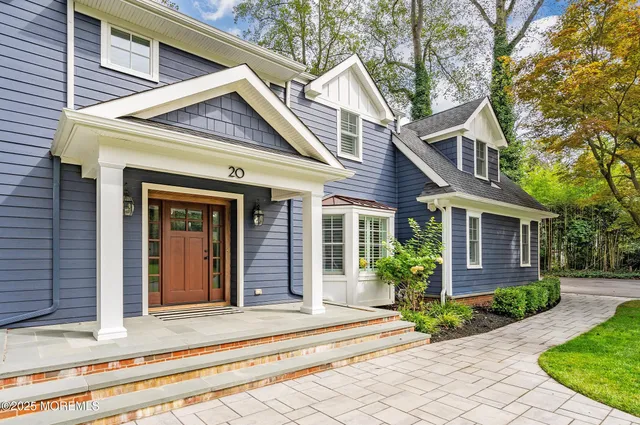 a view of a house with a small yard plants and large tree