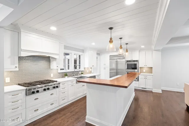 a kitchen with stainless steel appliances kitchen island granite countertop a sink stove and refrigerator