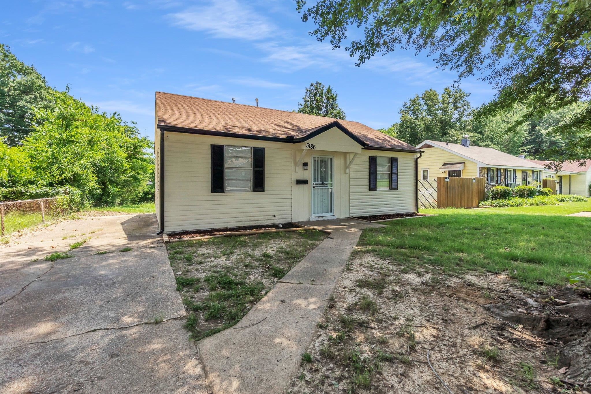 3186 Alta Road Memphis, TN 38109 - Photo 2 of 14 Siding exterior with contrasting dark shutters, a covered entry, and a paved driveway
