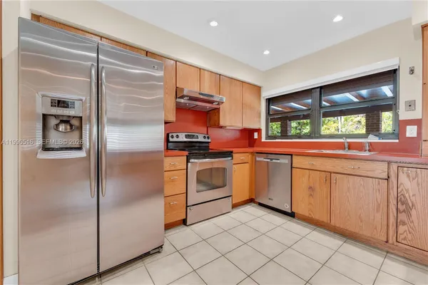 a view of kitchen with refrigerator and window