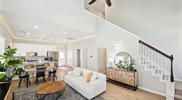 a living room with furniture kitchen view and a wooden floor