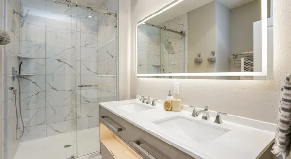 a bathroom with a sink shower and a mirror