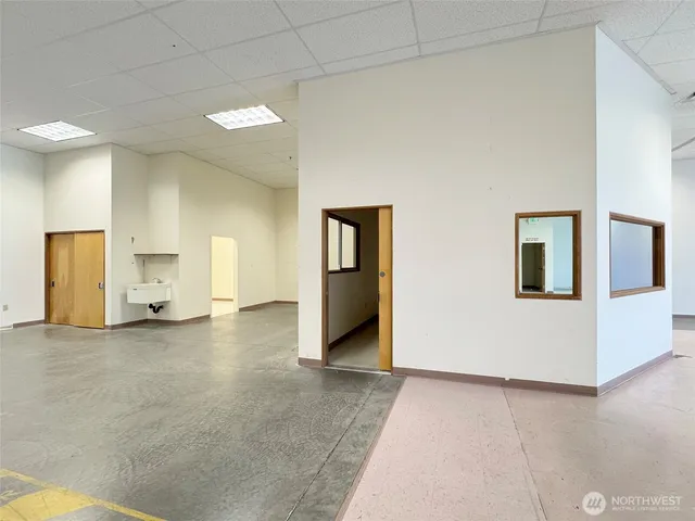 a view of a hallway with wooden floor and a living room