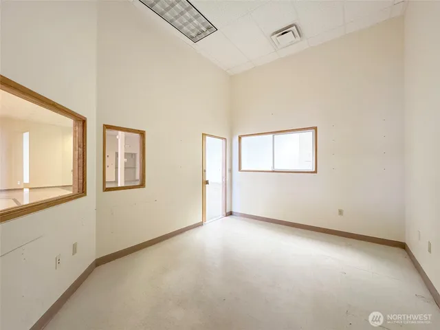 a view of a livingroom with wooden floor and kitchen space