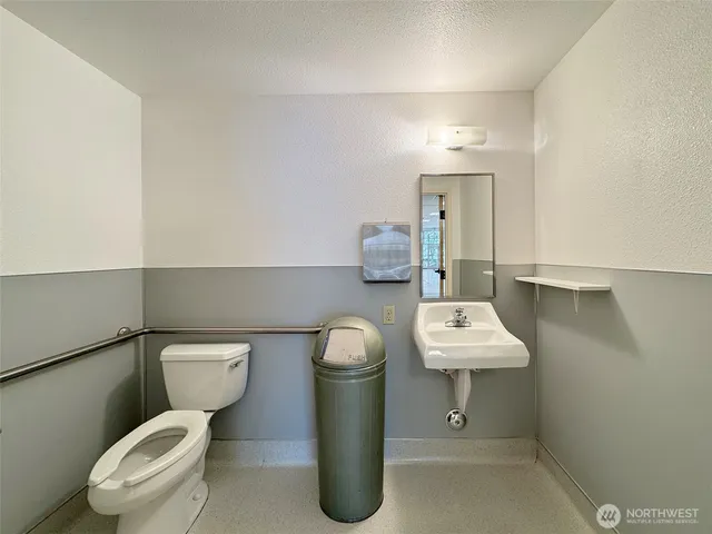 a bathroom with a toilet sink and mirror