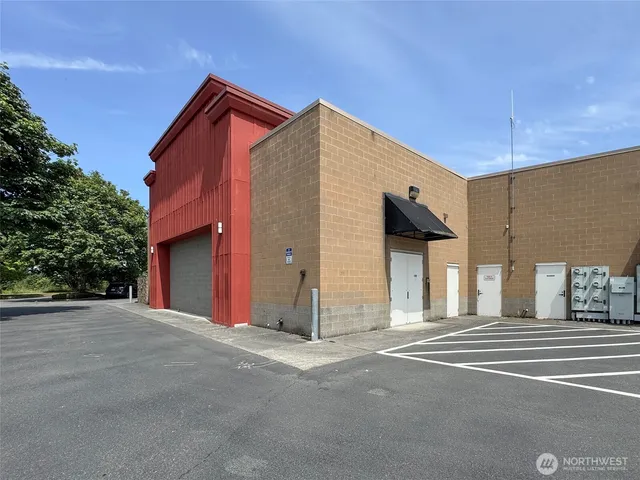 an aerial view of a city with lots of residential buildings and ocean view in back