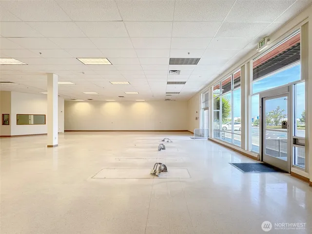 a view of a hallway with wooden floor and a large window