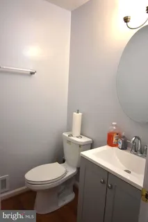 a bathroom with a toilet a sink and mirror
