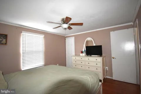 a bedroom with a bed and a ceiling fan