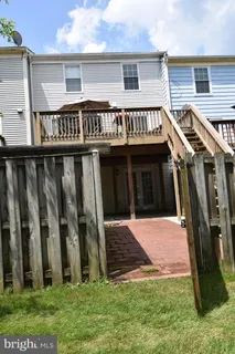 a view of wooden house with a deck and furniture