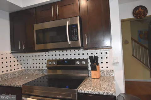 a bathroom with granite countertop a sink a stove and microwave