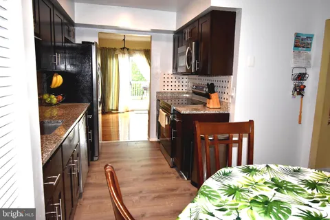 a kitchen with granite countertop a refrigerator stove and sink