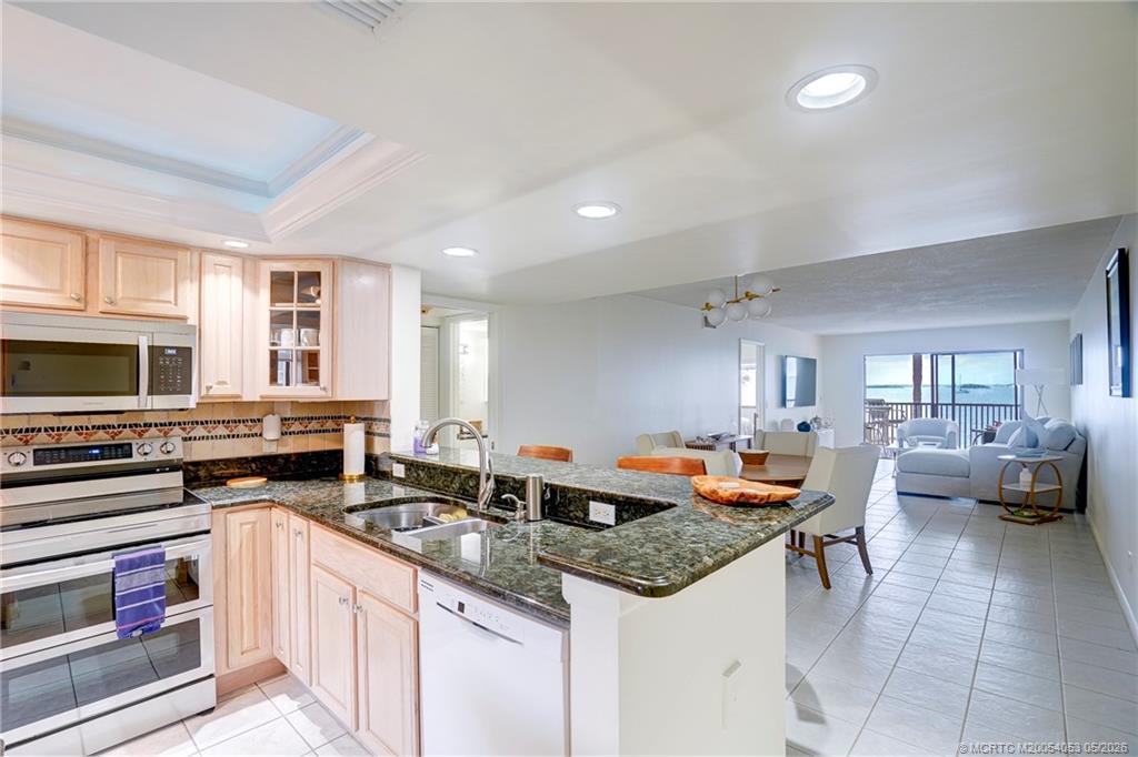 10 Northeast Plantation Road, Unit 101 Jensen Beach, FL 34957 - Photo 6 of 53 a kitchen with stainless steel appliances granite countertop a sink and cabinets