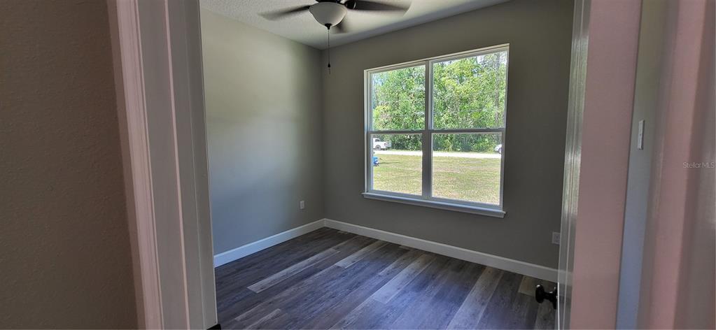 1666 Berrybush Street Bunnell, FL 32110 - Photo 15 of 26 a view of an empty room with wooden floor and a window