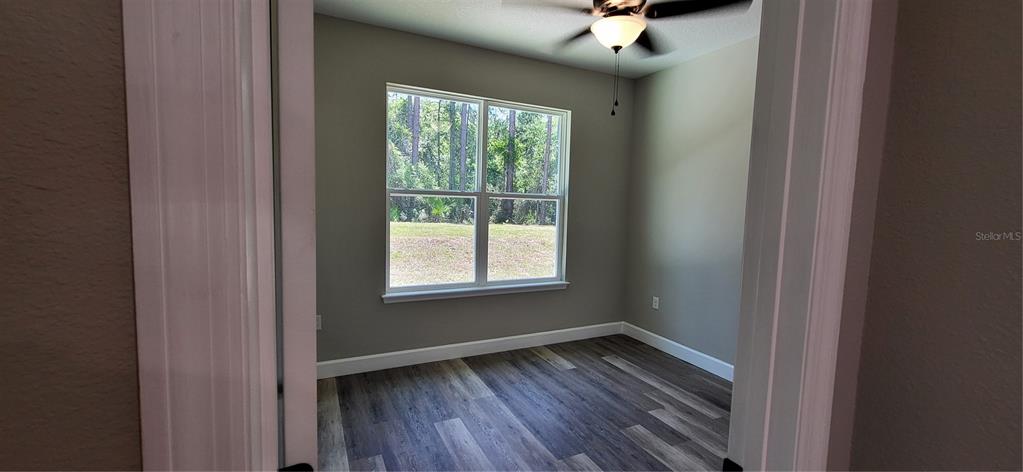 1666 Berrybush Street Bunnell, FL 32110 - Photo 17 of 26 a view of an empty room with wooden floor and a window