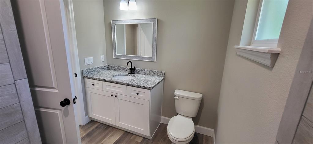 1666 Berrybush Street Bunnell, FL 32110 - Photo 20 of 26 a bathroom with a granite countertop toilet and a sink