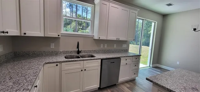 a kitchen with a sink cabinets and window